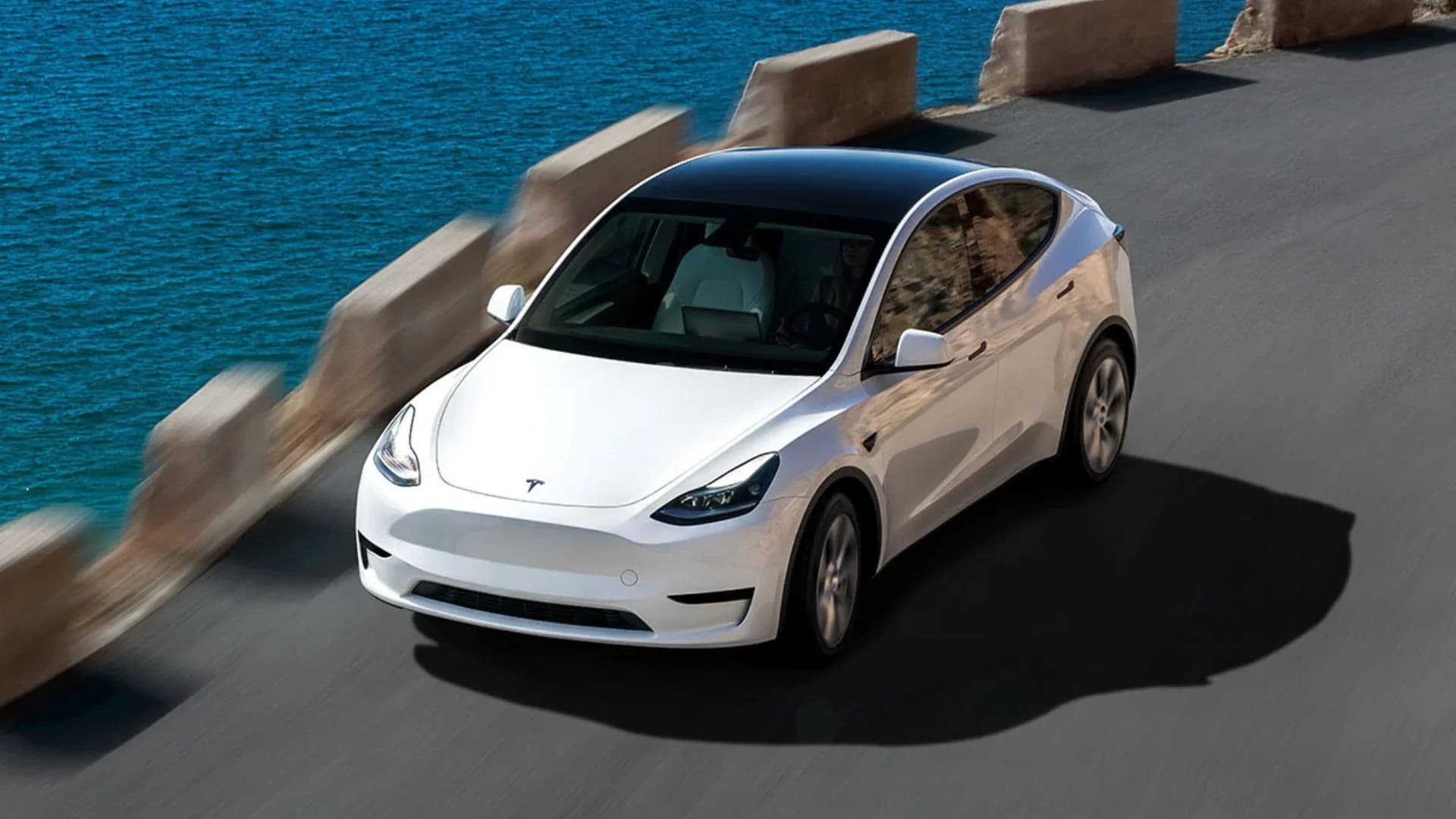 Tesla vehicle driving itself on an open road, illustrating the tesla autonomous future