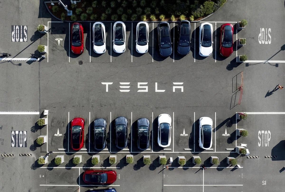 Tesla self-driving cars navigating a city street with no hands on the wheel