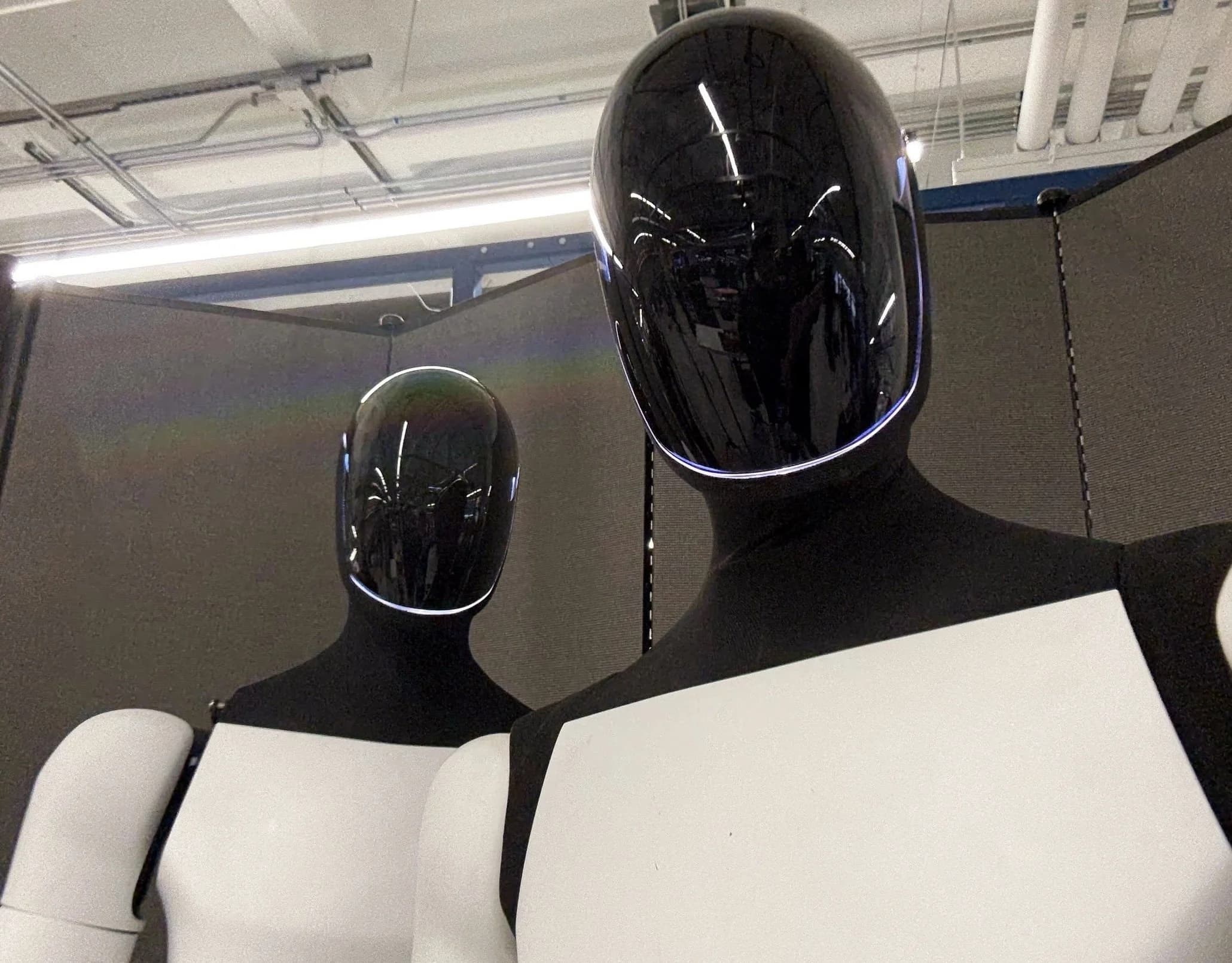 Tesla Optimus robot standing in a factory setting, showing its humanoid design and dexterous hands