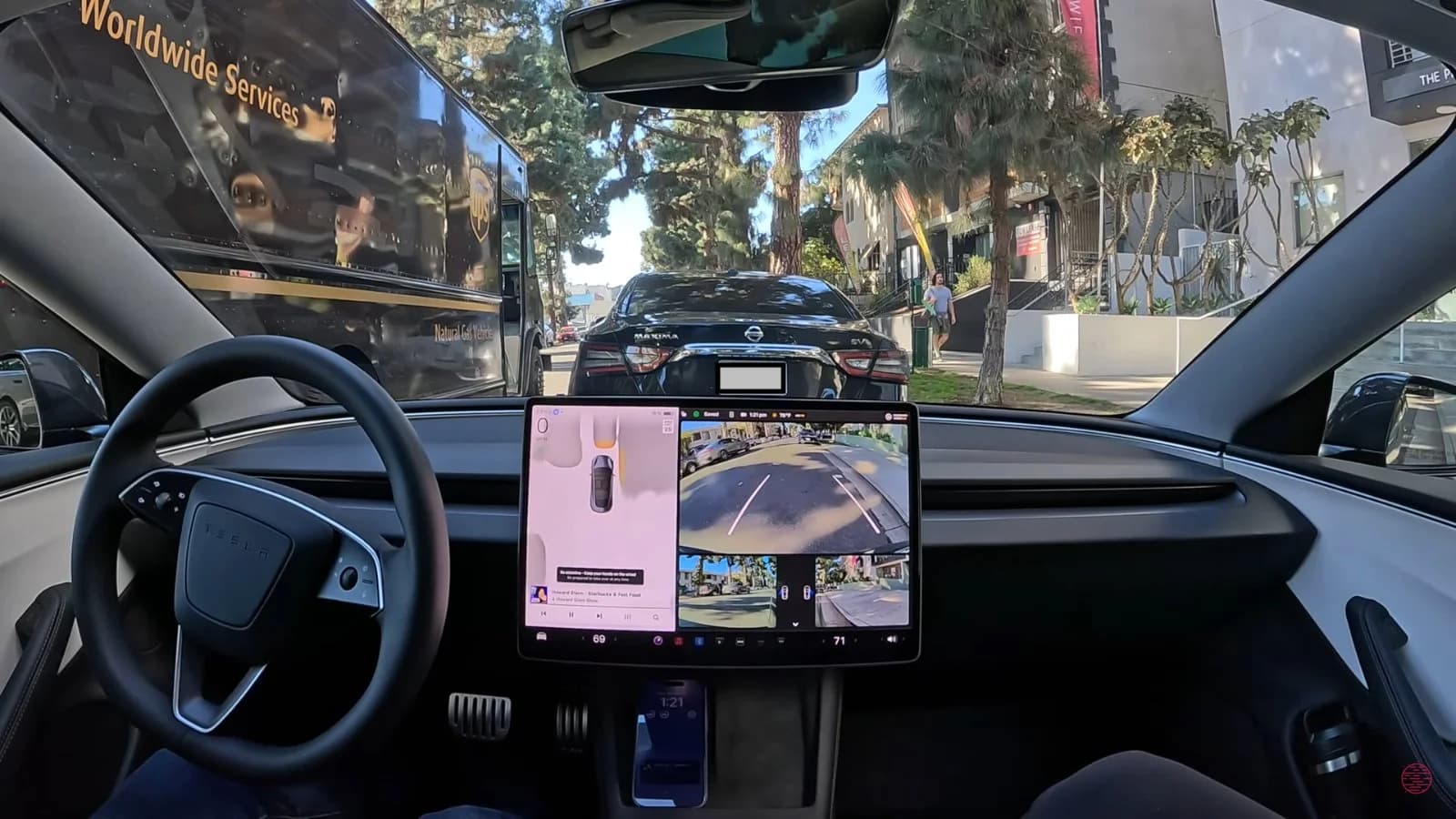 Tesla vehicle running FSD v14 navigating a complex street scene with pedestrians and traffic