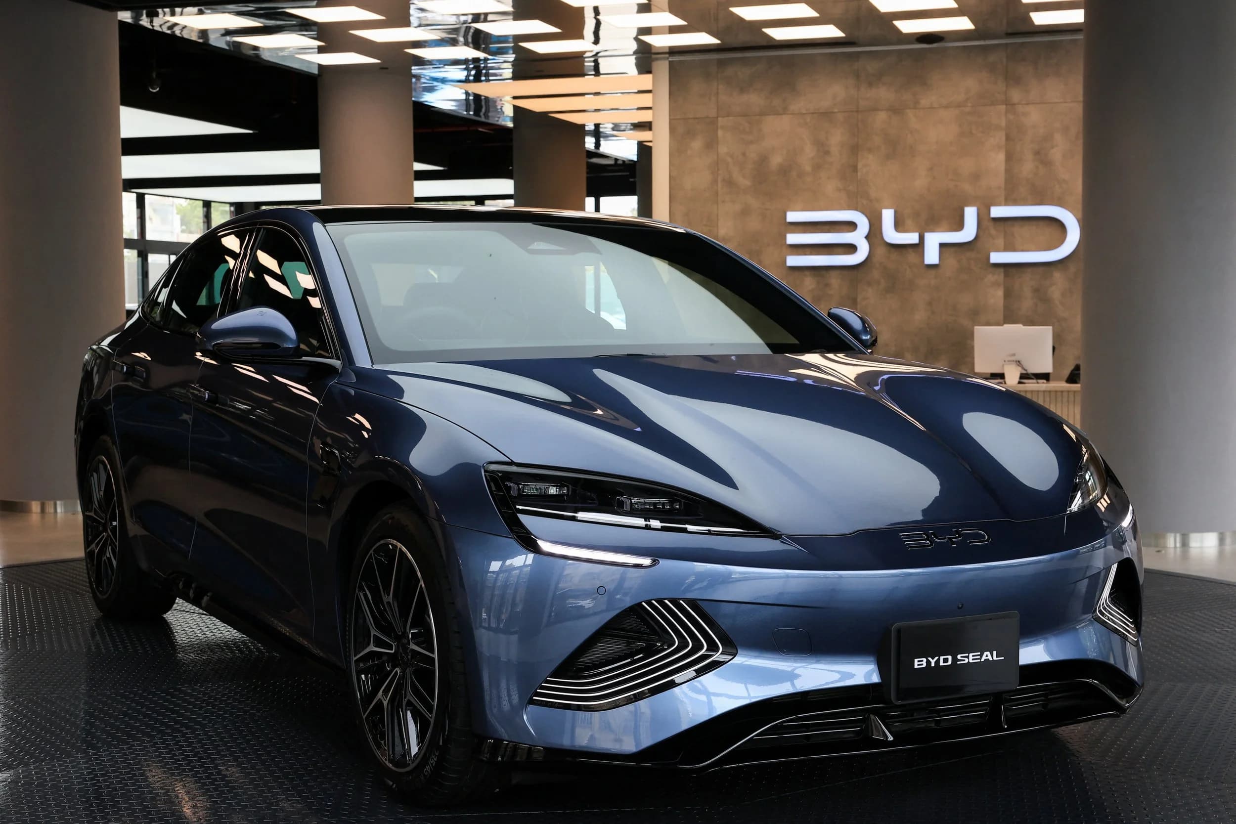 Tesla stock valuation chart at $1.5 trillion beside declining 2025 delivery numbers and BYD comparison