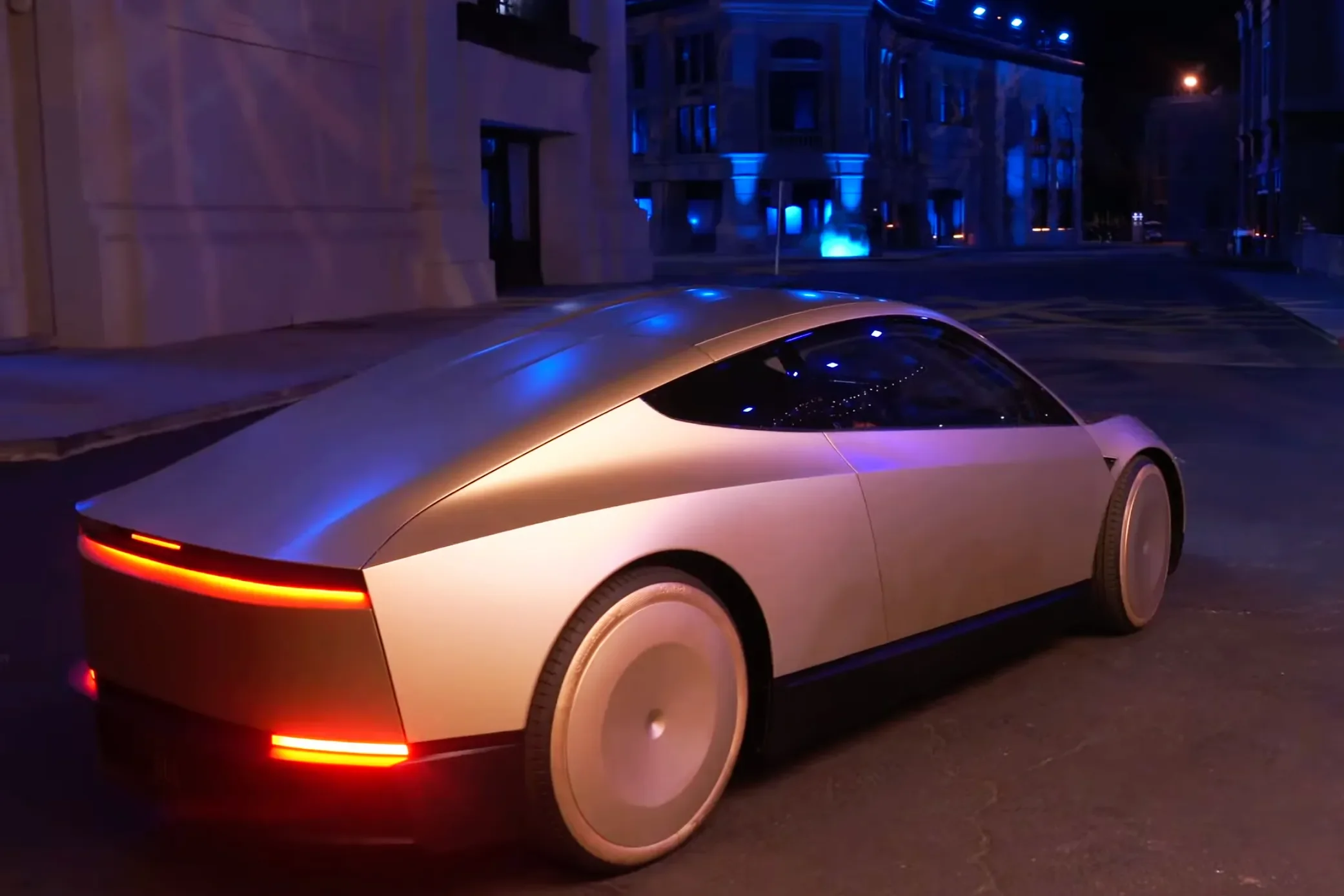 Tesla Cybercab production prototype on a city road with no steering wheel or pedals