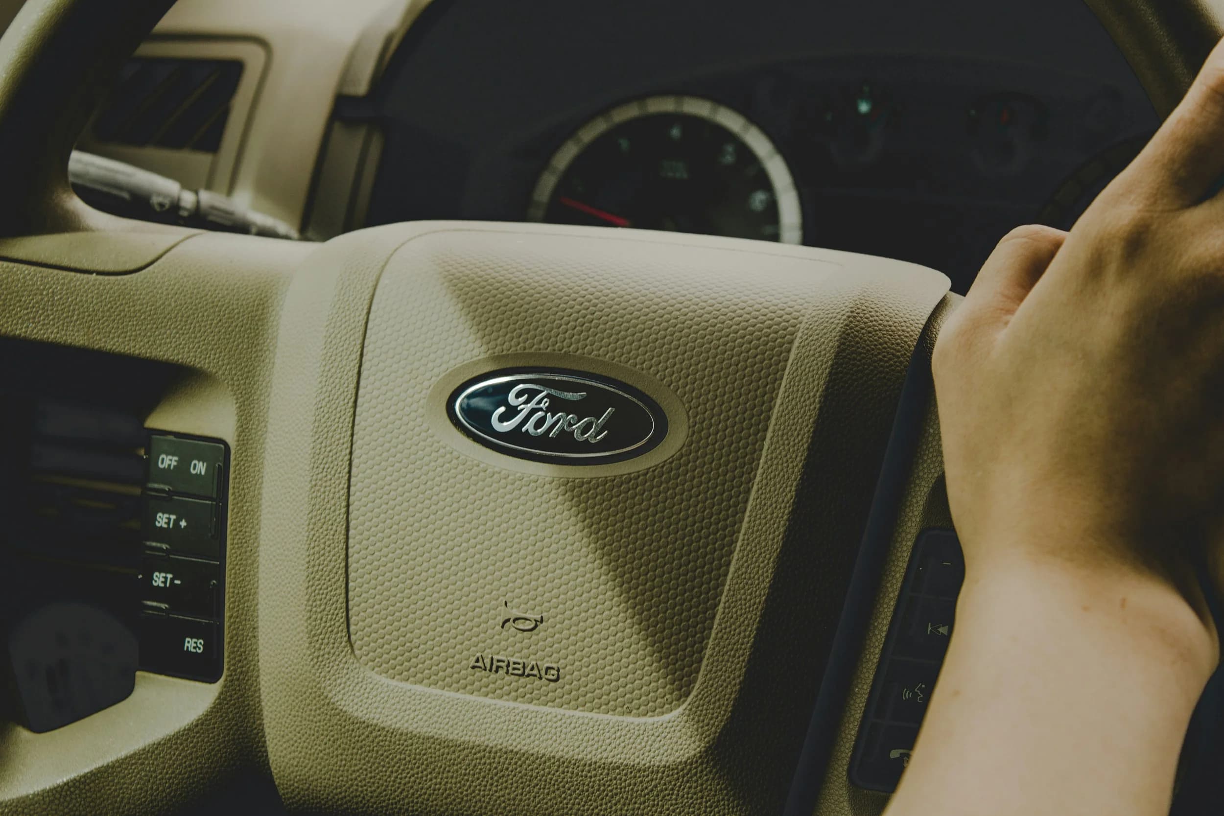 Ford EV write-down concept with an electric truck and falling investment chart over a factory line
