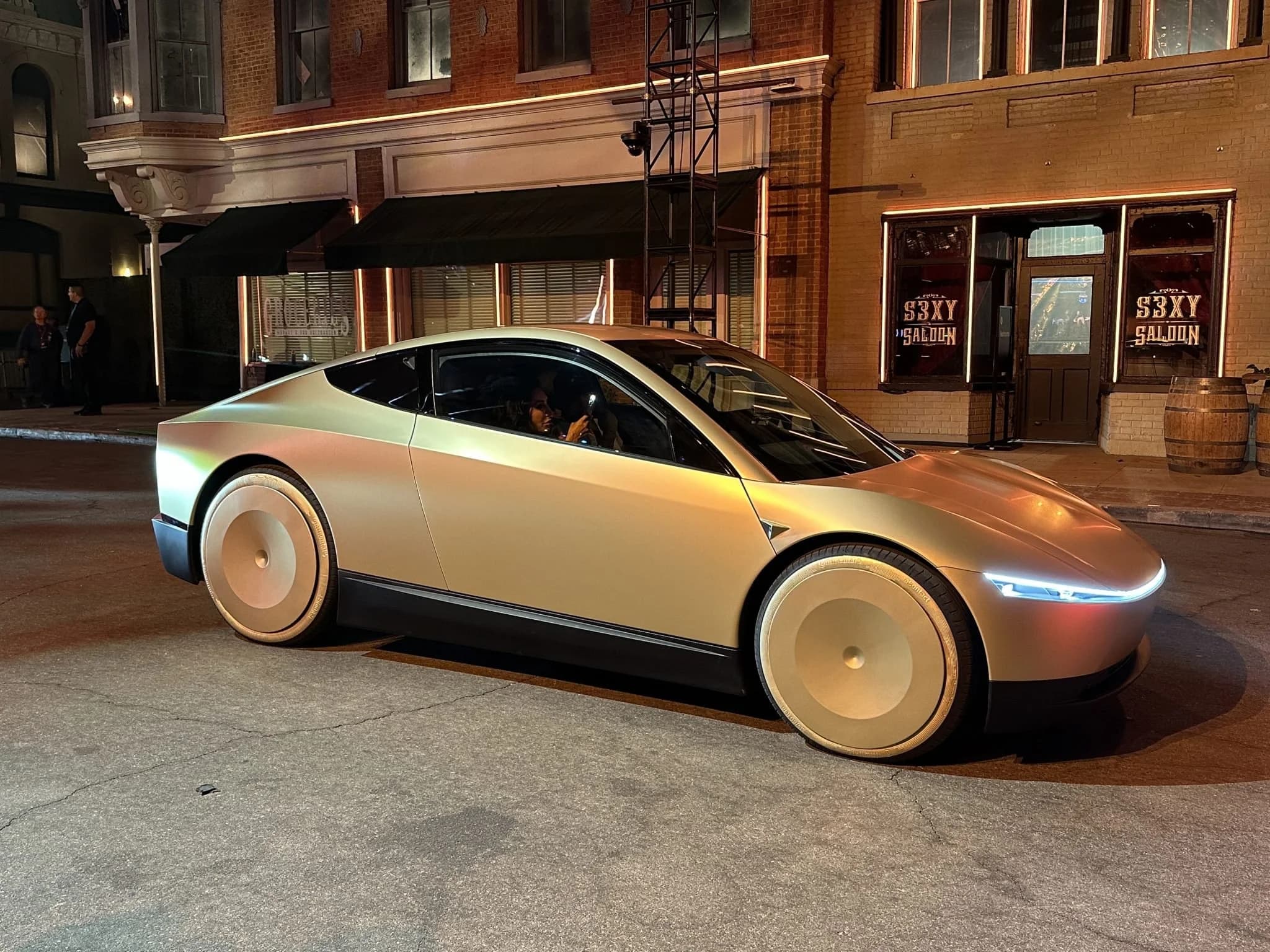 Tesla Cybercab parked on a city street, positioned as an affordable self-driving EV under $30,000